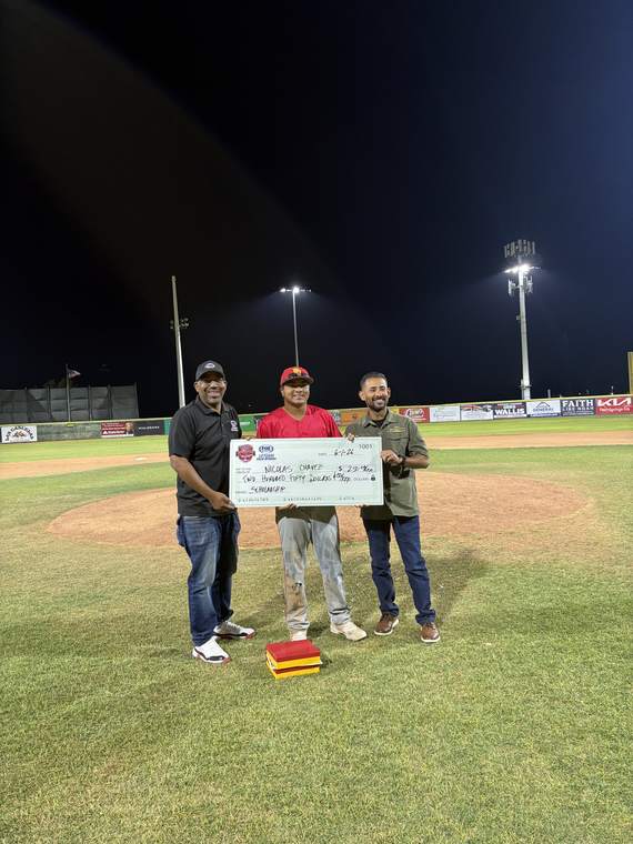 Presenting a donation on the field at a youth baseball event
